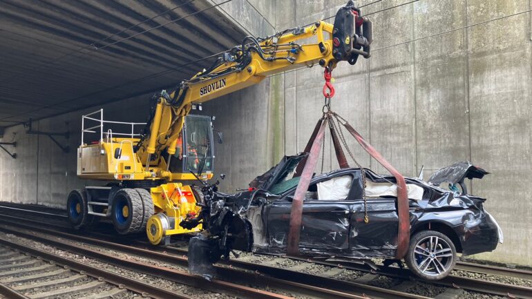 Car drives over bridge crashing onto rail line causing travel chaos